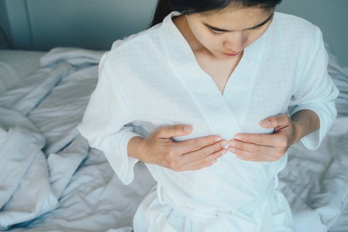 Woman-doing-self-exam for breast cancer- Metropolises