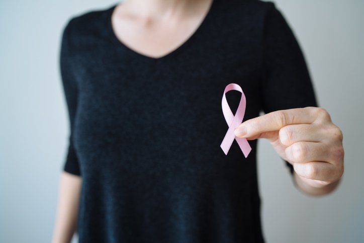 Woman holding pink October symbol - Metropolises