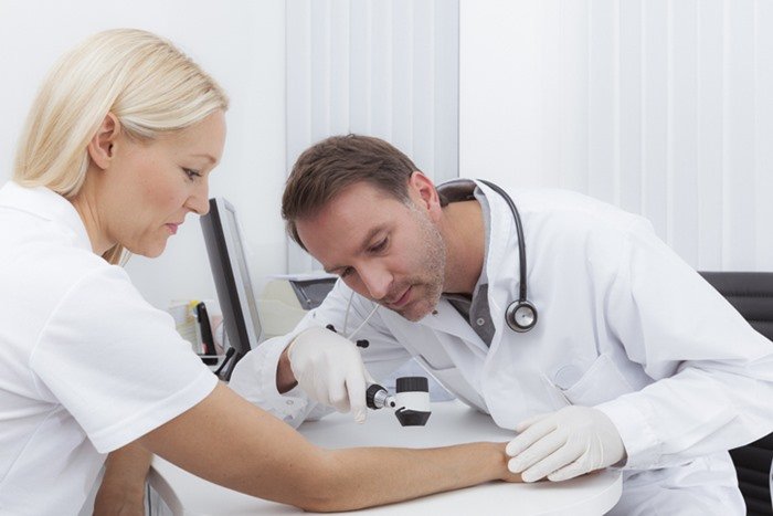 Doctor investigating patient's skin