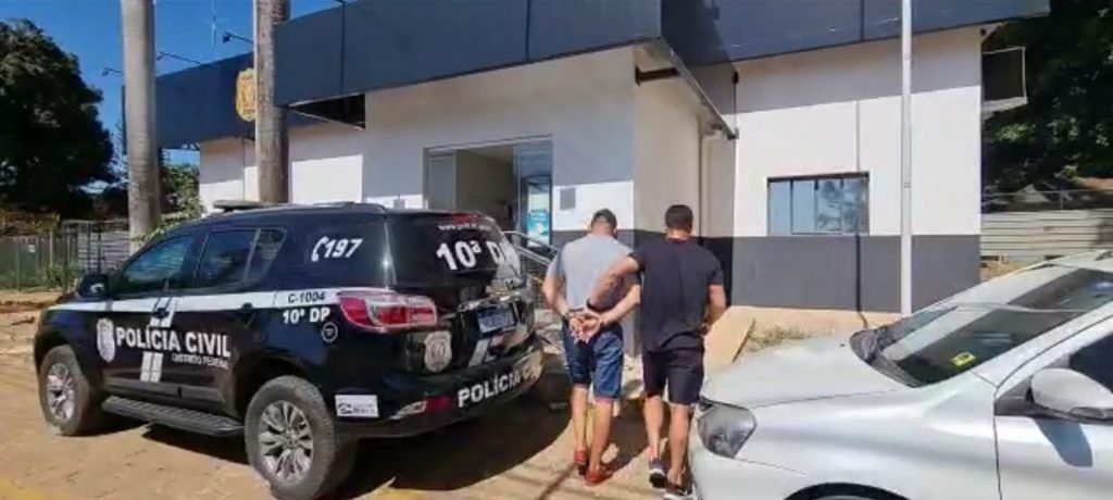 Homem preso é levado por policial