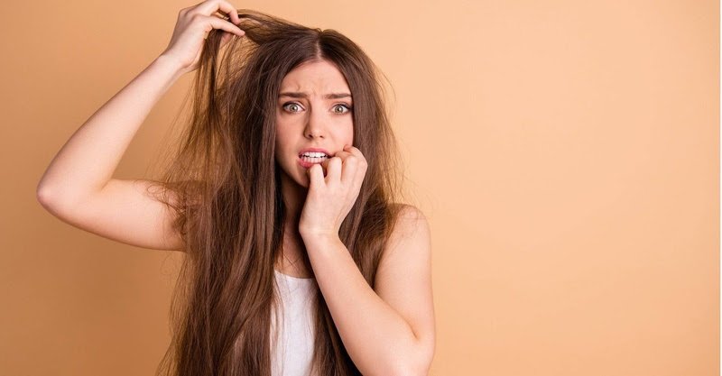 Mulher branca com a mão no cabelo