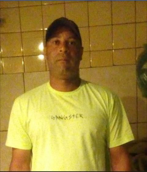 Homem de blusa amarela e boné preto