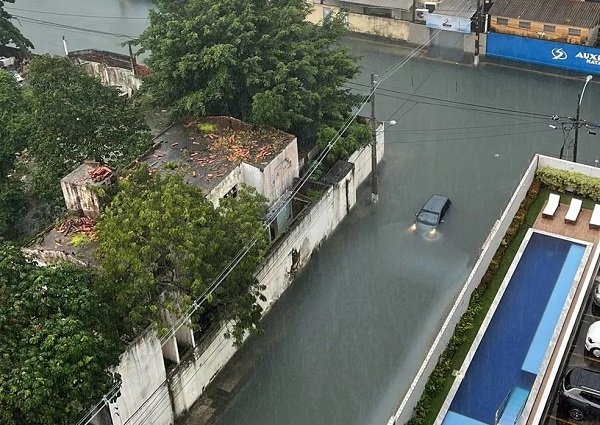 carro quase submerso em rua alagada