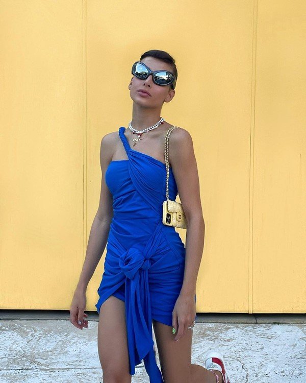 Na imagem com cor, Lívia Nunes usa vestido azul