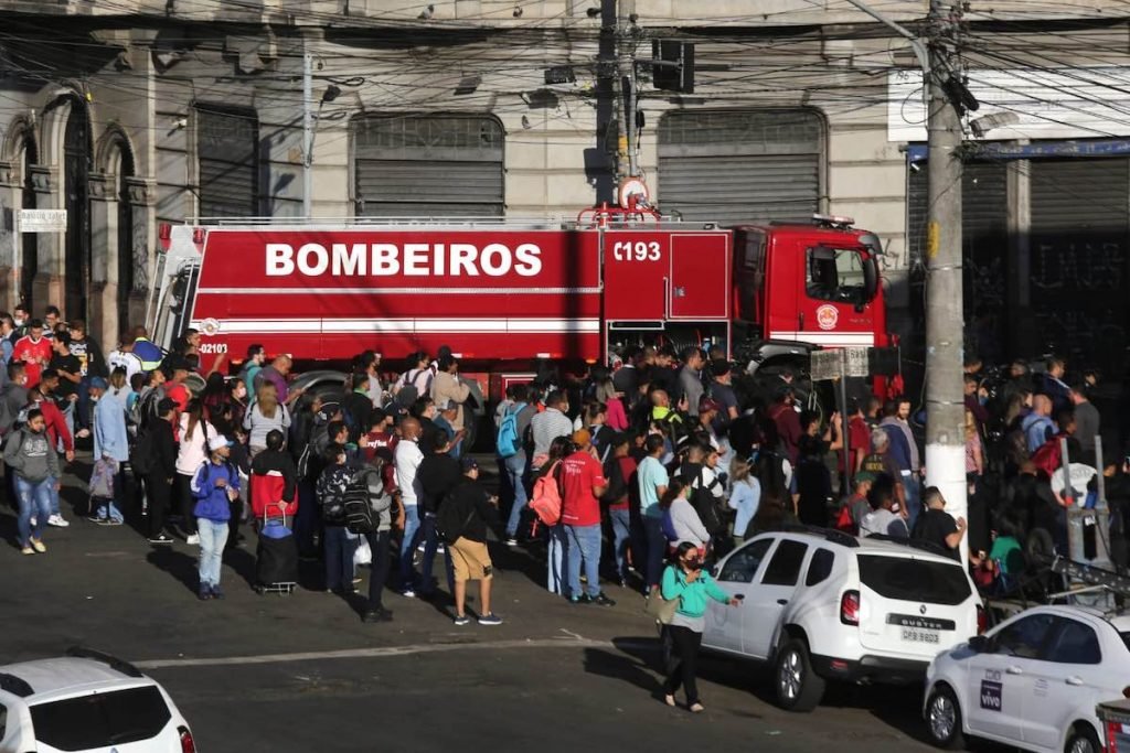 Equipes trabalham no rescaldo do incêndio que atingiu o edifício em uma paralela à Rua 25 de Março, conhecida pelo comércio