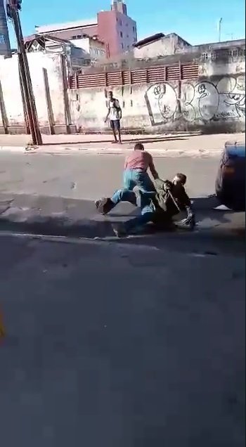 Homem de camisa vermelha cai em cima de outro