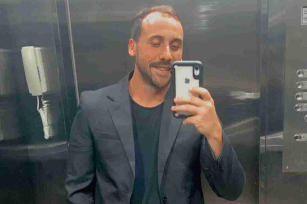 Anestesista Giovanni Quintella Bezerra, flagrado estuprando mulher grávida durante parto, tira foto com seu celular em espelho de elevador. Ele usa terno e blusa preta - Metrópoles