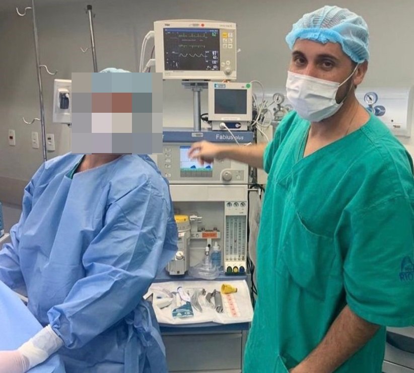 Anestesista Giovanni Quintella Bezerra, flagrado estuprando mulher grávida durante parto, fotografado com outra profissional médica durante cirurgia. Ele usa uniforme e máscara - Metrópoles