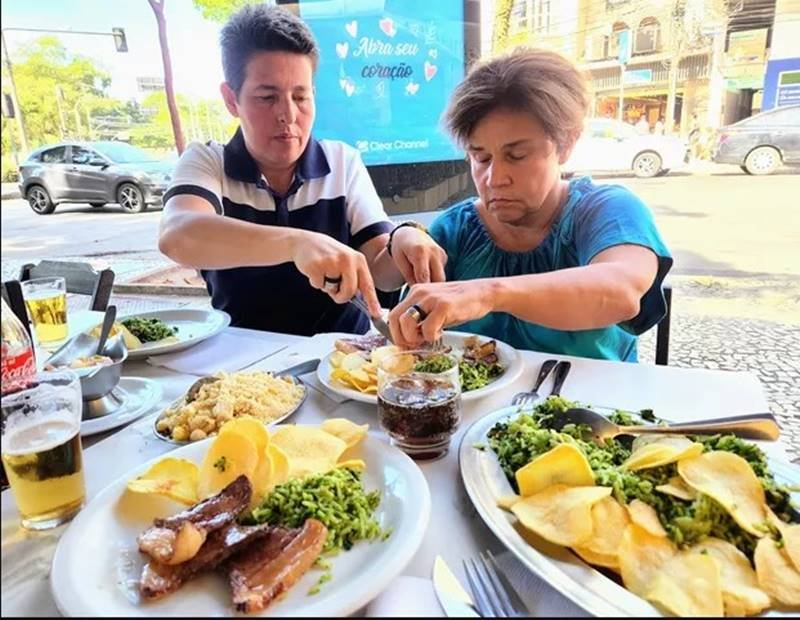 Foto de uma mulher ajudando uma senhora a comer-Metrópoles