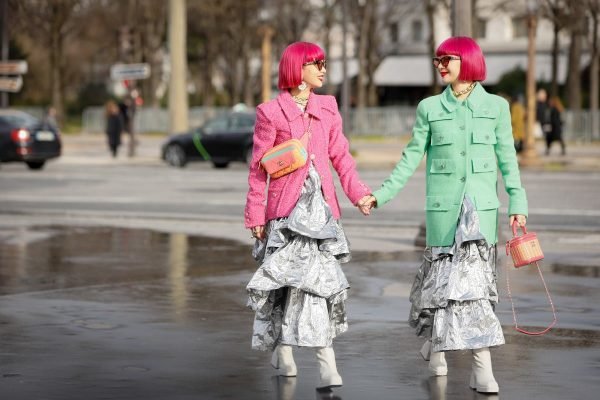 Duas mulheres brancas andando na rua com peça de babado