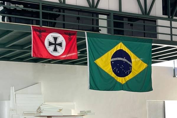Fotografia colorida com duas bandeiras penduradas lado a lado