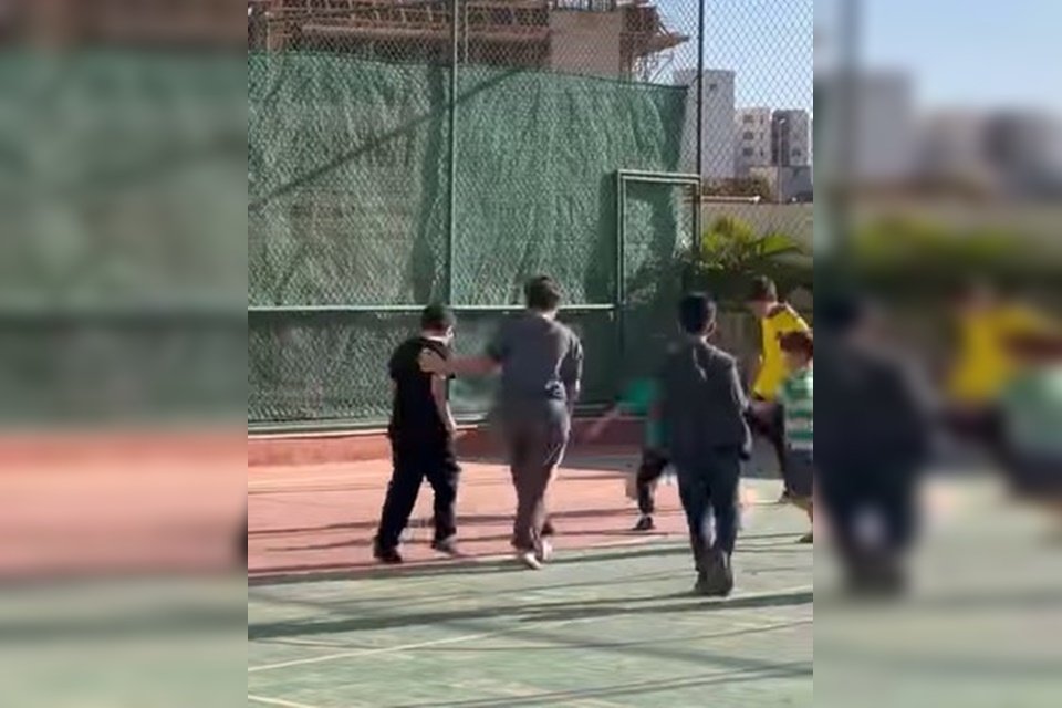 Meninos jogando futebol em quadra poliesportiva