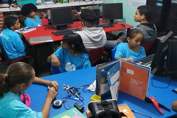 Foto de várias crianças sentadas em frente a computadores