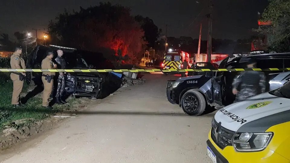 Local de confronto entre homem que reagiu à abordagem policial e acabou morto no limite de Curitiba e Almirante Tamandaré. Vê-se uma faixa de isolamento, policiais fazendo ronda e diversas viaturas já à noite - Metrópoles