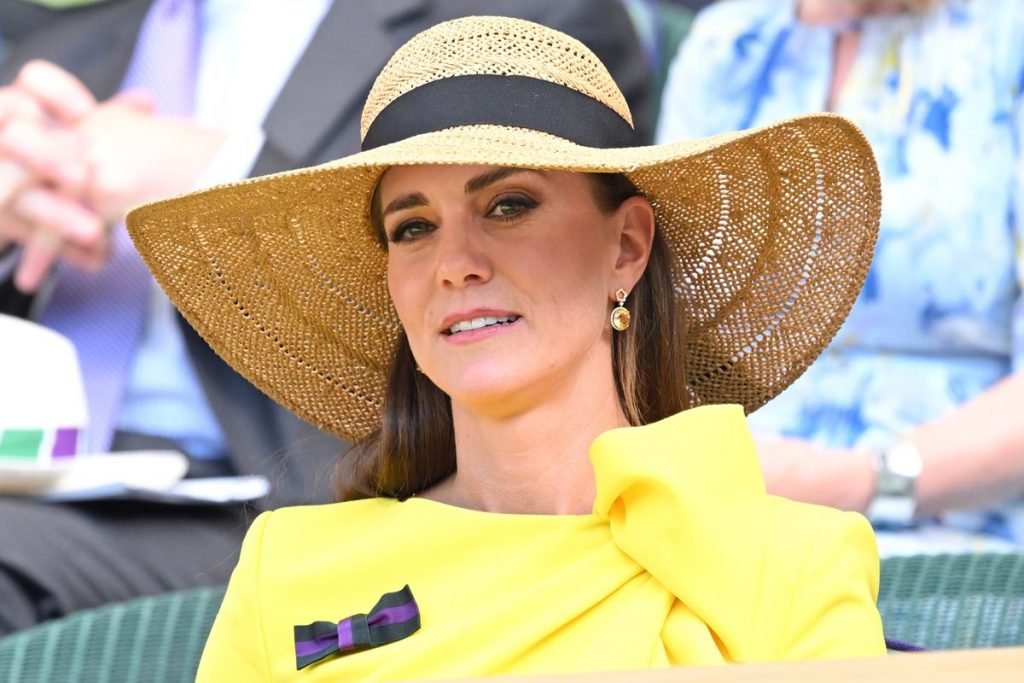 Na foto, mulher branca de chapéu marrom e um vestido amarelo - Metrópoles