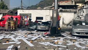 Explosão em posto de combustível deixa carros e estrutura do local destruído no Rio de Janeiro. Na foto, bombeiros socorrem feridos em meio a escombros - Metrópoles