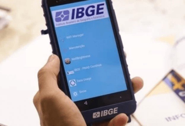 Pessoa segurando celular com aplicativo do IBGE-Metrópoles