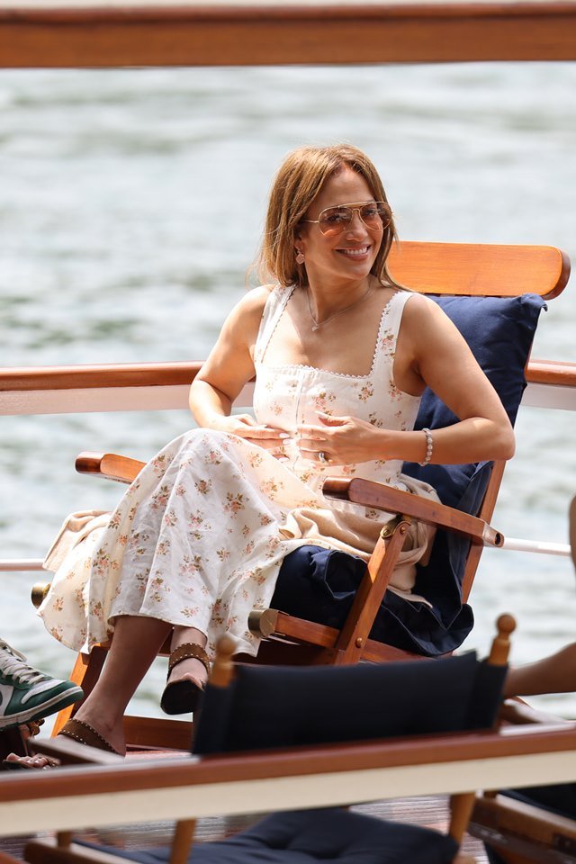 Foto colorida. Mulher sentada em uma cadeira dentro de um barco