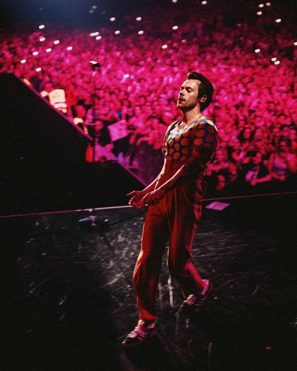 Harry Styles em palco de show usando look vermelho da Gucci