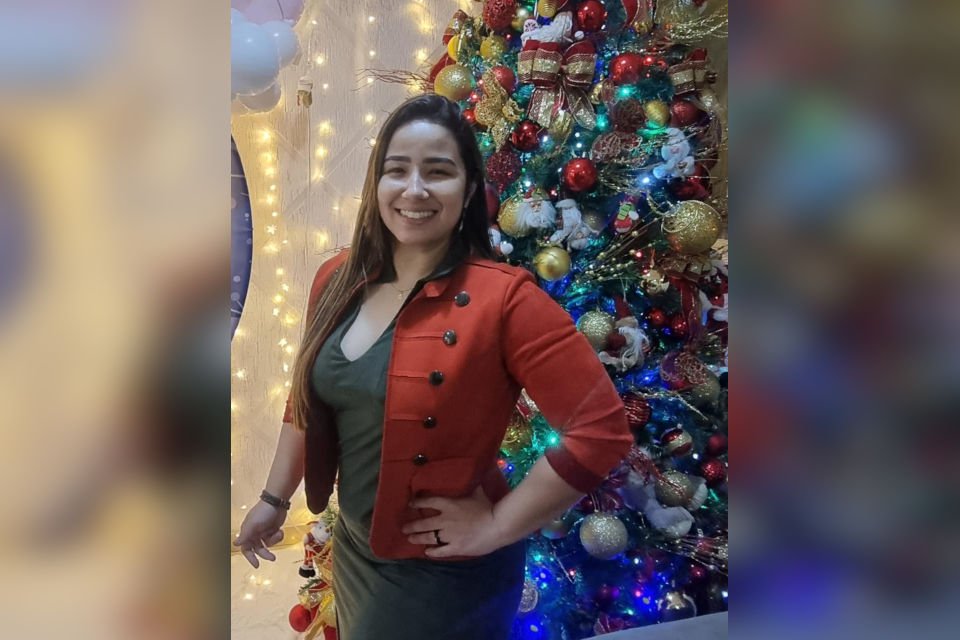 mulher em frente a árvore de natal