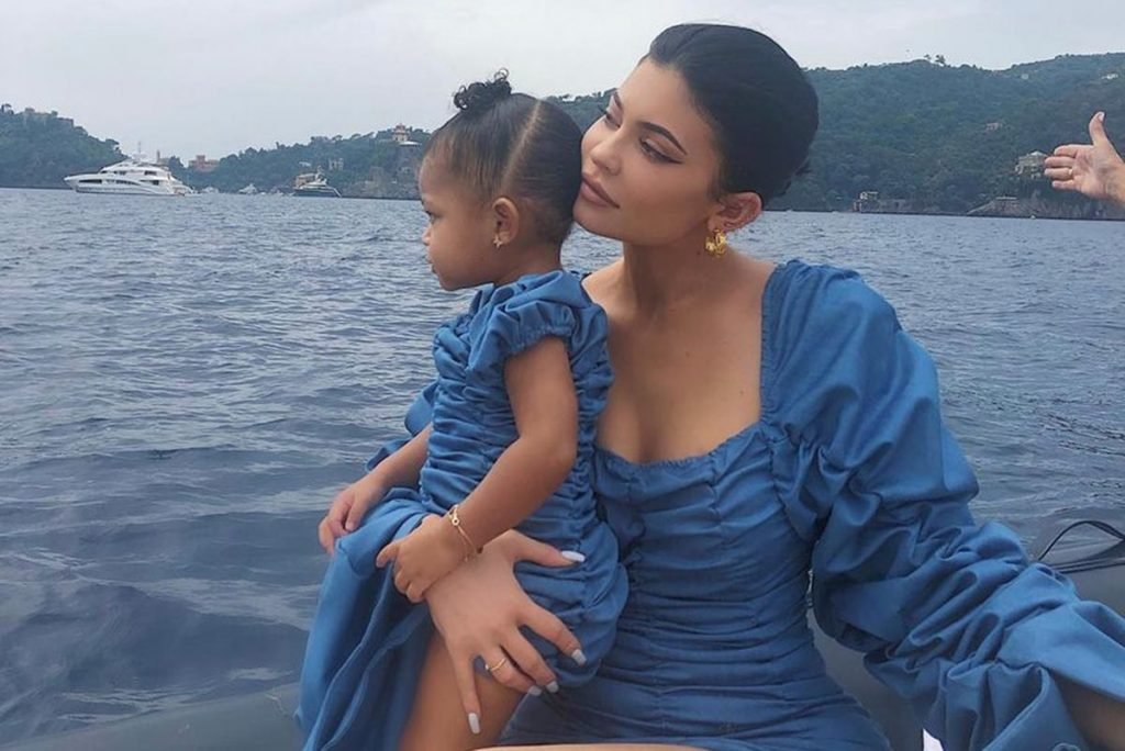 Foto colorida de Kylie Jenner e da filha, Stomi Webster. Elas estão de azul e combinaram o look - Metrópoles