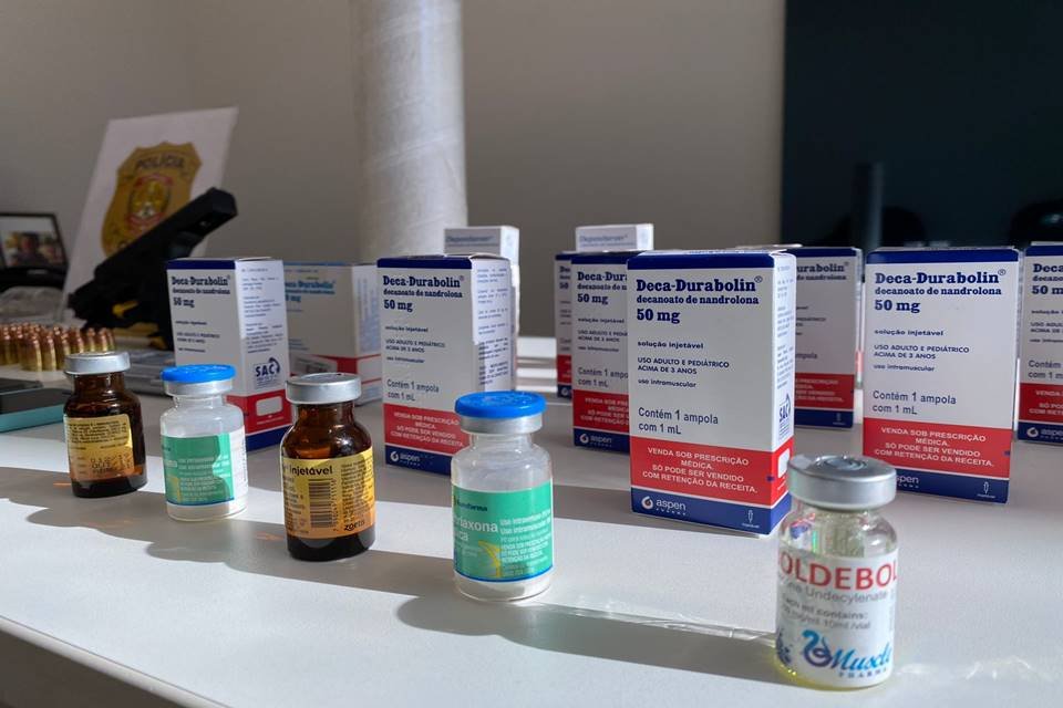 foto colorida de frascos de medicamento sobre uma mesa branca