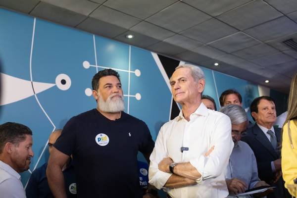 Imagem colorida de dois homens, um de camiseta azul e outro de camisa branca