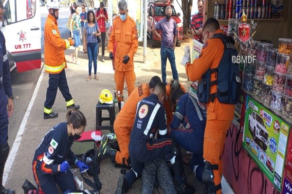 Foto de bombeiros reanimando mulher no chão
