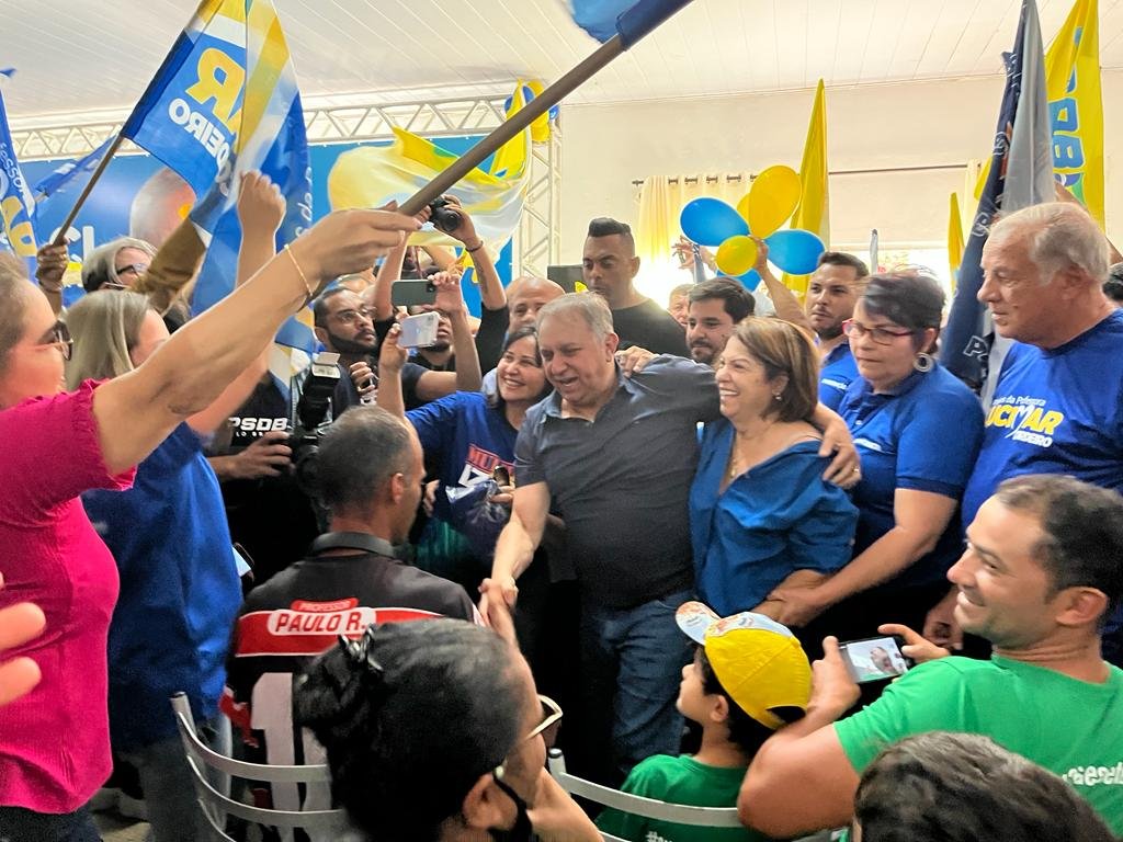 foto colorida homens e mulheres com roupas azuis e amarelas abraçados