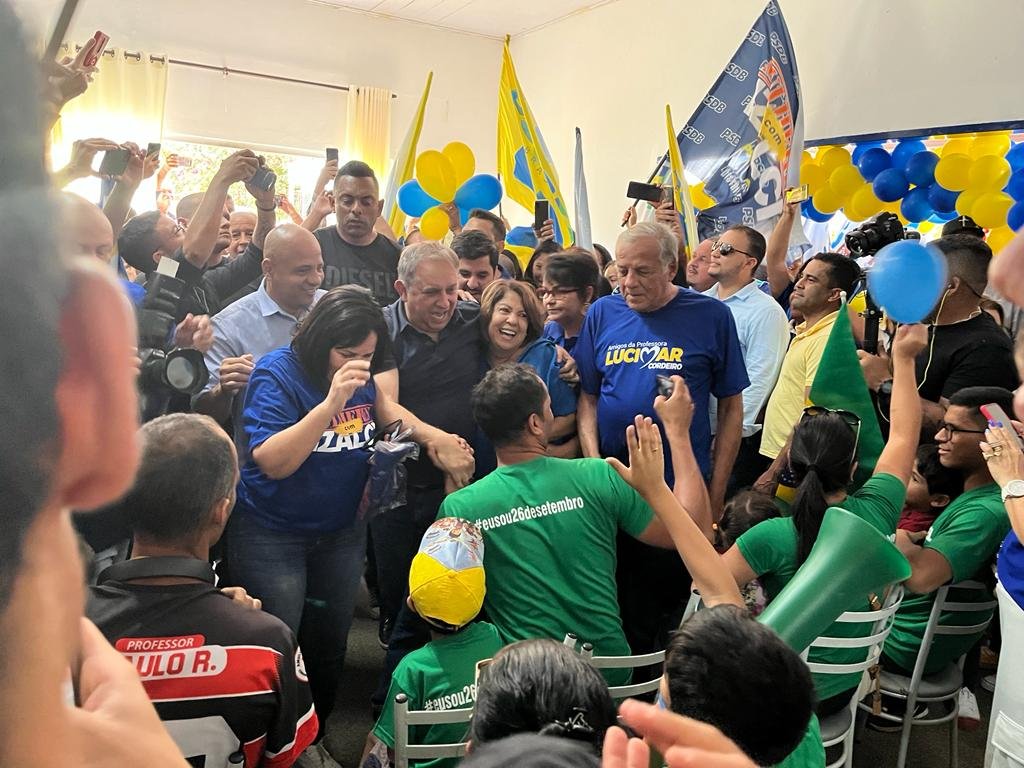foto colorida homens e mulheres com roupas azuis e amarelas abraçados