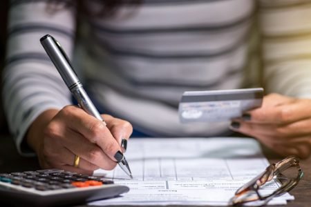 pessoa fazendo contas cartão de crédito