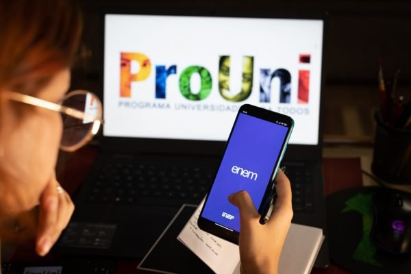 tela computador com site do Prouni e celular comtela computador com site do Prouni e celular com app do Enem app do Enem