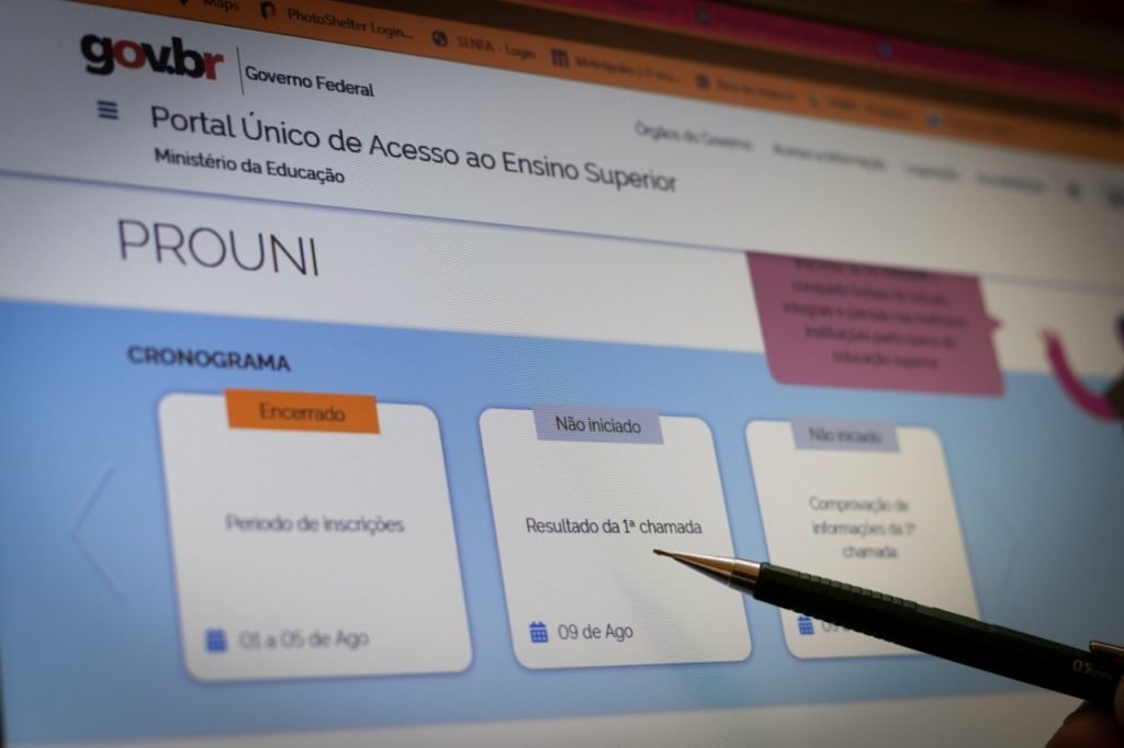 estudante aponta para tela do computador com site do Prouni