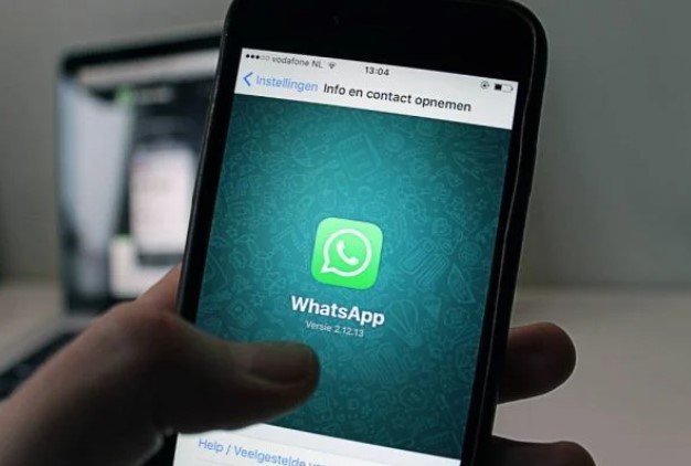 Pessoa segurando celular com WhatsApp aberto - Metrópoles