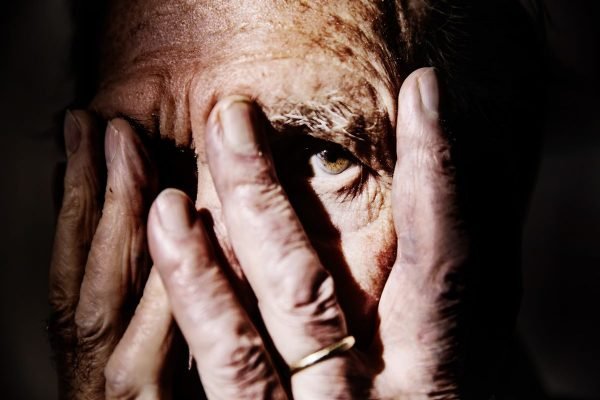 Imagem colorida mostra idoso cobrindo o rosto com as mãos - Metrópoles