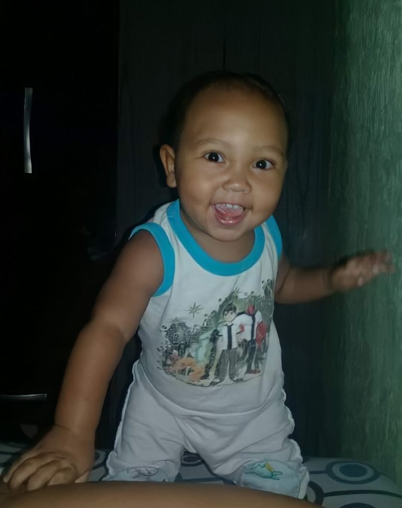 Bebê moreno e com cabelo raspado sorrindo