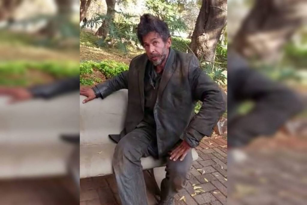 Morador de rua sentando em banco de praça - Metrópoles