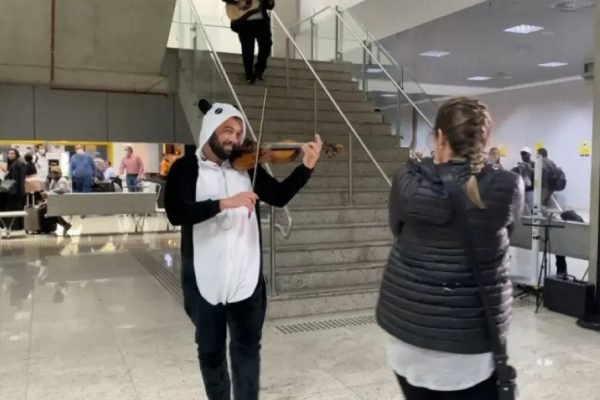 foto colorida de homem vestido de panda em aeroporto