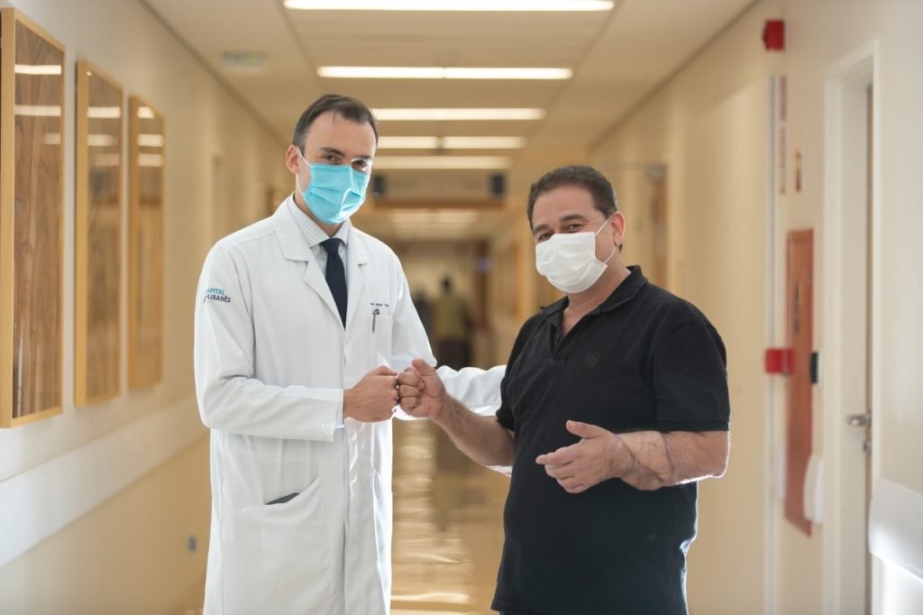 fotografia colorida de médico e paciente no corredor de um hospital