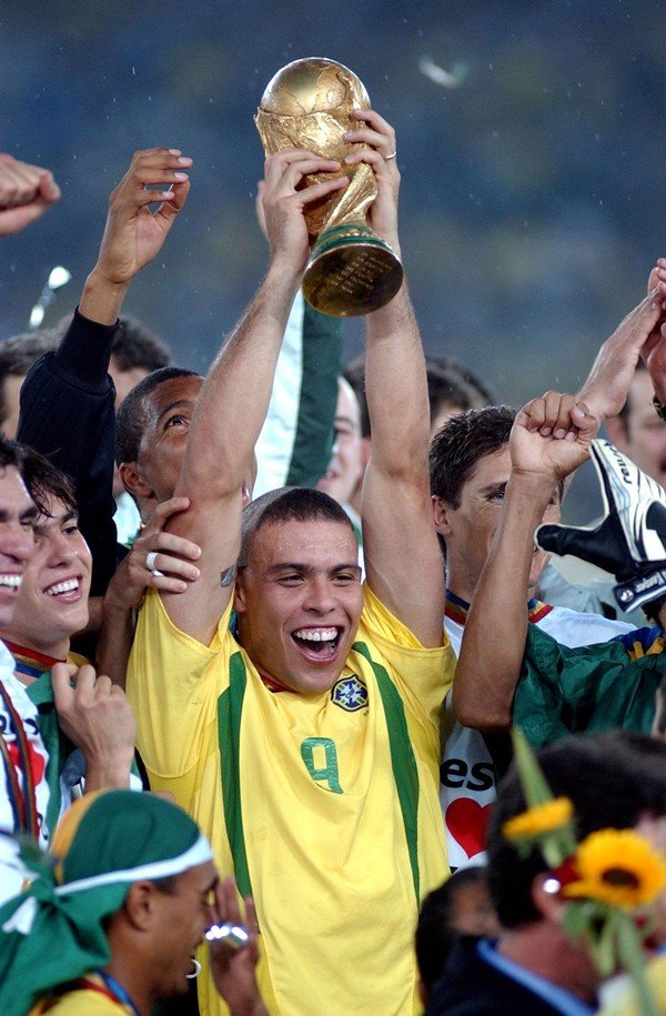O jogador de futebol Ronaldo levantando a taça do campeonato que a seleção ganhou: 2002, Copa do Mundo do Japão e da Coreia do Sul