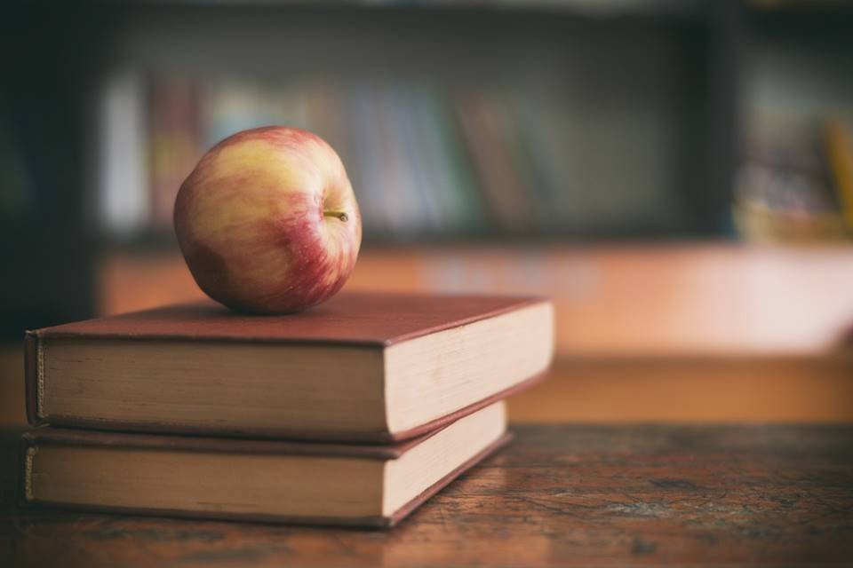 maça em cima de livros
