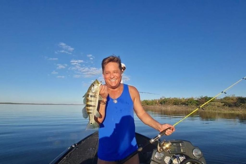 Cantor Leonardo com regata azul seguindo um peixe dentro de um barco - Metrópoles