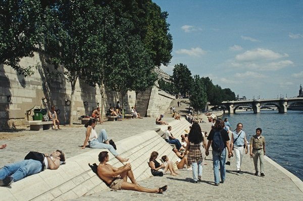 Pessoas passeando, tomando sol e lendo às margens do Rio Siena, em Paris, na França. É um dia de verão ensolarado
