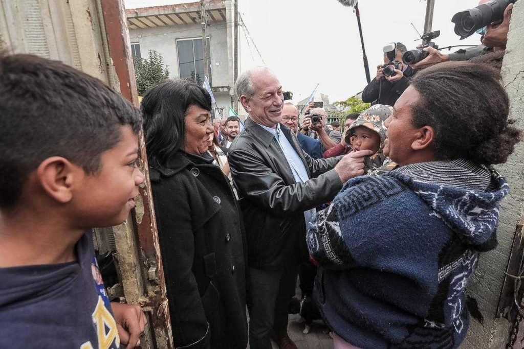Ciro Gomes segura criança em visita à Vila Nova Esperança, Curitiba (PR)