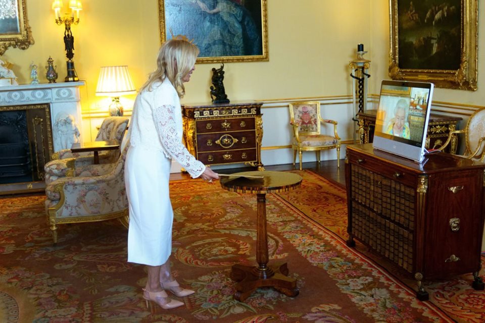 Foto colorida. Mulher de roupa branca em uma sala