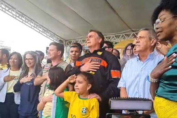 O presidente Jair Bolsonaro ao lado de aliados durante a execução do hino nacional brasileiro