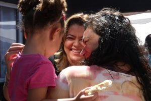 Candidata sorri com mulher e criança