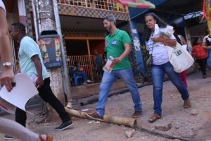 Candidato caminhando ao lado de duas pessoas