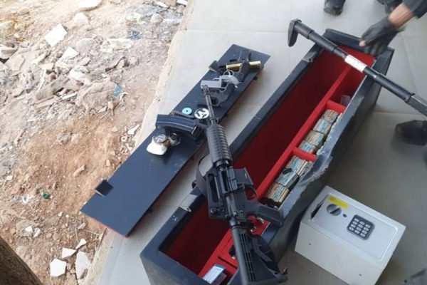 foto colorida de fuzil, pistola, revólveres e dinheiro