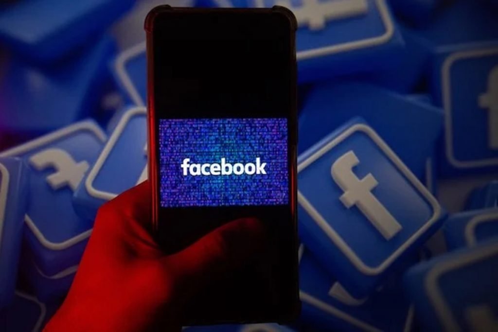 Foto de um celular com o ícone do Facebook